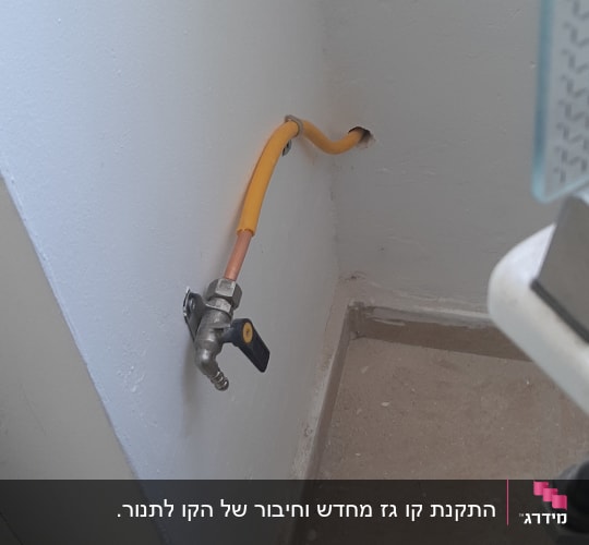 צינור גז צהוב עם ברז מתכת על קיר לבן